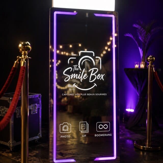 Miroirbooth The Smile Box éclairé en violet à l’entrée d’une soirée